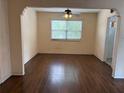 Open dining room space featuring hardwood floors, natural light from a large window, and ceiling fan at 1902 W Aileen St, Tampa, FL 33607