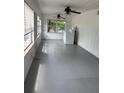 Sun-filled Florida room with gray painted floors, washer, lots of windows, and multiple ceiling fans at 1902 W Aileen St, Tampa, FL 33607
