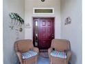 Cozy front porch with two wicker chairs with striped cushions and decorative seaside ornaments at 2018 E Del Webb Blvd, Sun City Center, FL 33573