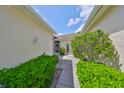 Walkway from the main driveway with lush greenery, leading to the home's front door at 2220 Nantucket Dr # 43, Sun City Center, FL 33573