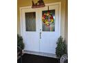 Inviting front door with decorative wreath and 'Peace on Earth' sign, flanked by potted plants at 2704 E Montague E Ct, Clearwater, FL 33761