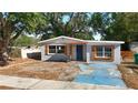 Charming single-story home with blue door and light-grey paint on a sunny day at 3020 E Louisiana Ave, Tampa, FL 33610