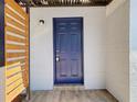 A close-up of a dark blue, six-panel front door with wood accent at 3020 E Louisiana Ave, Tampa, FL 33610