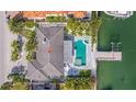 Aerial view of a home featuring a pristine pool, boat dock, and lush landscaping at 368 41St Ave, St Pete Beach, FL 33706