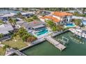 Home showcasing a waterfront backyard with a sparkling pool, dock, and lush landscaping at 368 41St Ave, St Pete Beach, FL 33706