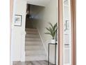 Inviting entryway featuring a staircase and a stylish accent table with a plant, adding a touch of nature at 375 Madeira Cir, St Petersburg, FL 33715