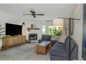 Cozy living room with a brick fireplace, ceiling fan, and stylish decor at 375 Madeira Cir, St Petersburg, FL 33715