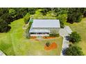 Expansive aerial view of this property featuring a metal roof, a large lawn and beautiful landscaping at 4702 Cypress Serenity Dr, Plant City, FL 33565