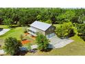 Stunning aerial view of the property highlighting the two-car garage and spacious surrounding yard with mature trees at 4702 Cypress Serenity Dr, Plant City, FL 33565