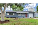Charming one-story home featuring a blue exterior, white awning and a well-manicured front lawn at 5772 4Th N Ave, St Petersburg, FL 33710