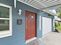 Close up on a red front door featuring a glass pane, mailbox, and adjacent to the garage at 5772 4Th N Ave, St Petersburg, FL 33710