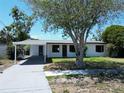 The exterior features a carport, a well-maintained lawn, and a freshly painted façade at 5812 Liverpool Dr, Tampa, FL 33615
