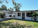Charming single-story home featuring a carport, manicured lawn, and fresh white paint at 5812 Liverpool Dr, Tampa, FL 33615