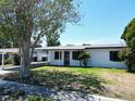 Exterior showcasing mature trees, freshly painted facade, and a convenient carport at 5812 Liverpool Dr, Tampa, FL 33615