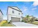 Two-story home featuring a neutral color palette, attached garage, and well-manicured landscaping at 582 Royal Empress Dr, Ruskin, FL 33570