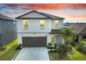 Inviting two-story home with landscaped yard and a spacious driveway leading to a two-car garage at 582 Royal Empress Dr, Ruskin, FL 33570