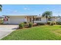 Beautiful home with a manicured lawn, lush landscaping, light brick, and a driveway at 742 45Th Ne Ave, St Petersburg, FL 33703