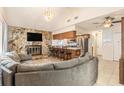 Cozy living room showcases stone fireplace, chandelier, and kitchen breakfast bar, ideal for relaxing and entertaining at 7426 Cay Dr, Port Richey, FL 34668