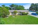 Charming single-story home with a well-maintained lawn and a blue car in the driveway at 8210 68Th N Way, Pinellas Park, FL 33781