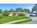 Charming single-story home with a well-maintained lawn and a blue car in the driveway at 8210 68Th N Way, Pinellas Park, FL 33781