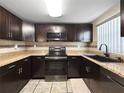 Modern kitchen with dark cabinetry, stainless steel appliances, and tile backsplash at 8210 68Th N Way, Pinellas Park, FL 33781