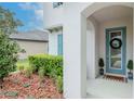 Home's charming entrance boasts beautiful landscaping and a welcoming front door with wreath at 8219 Summer Brook Ct, Land O Lakes, FL 34638