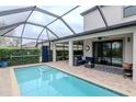Large screened-in pool with outdoor seating and a view of the peaceful green space at 8219 Summer Brook Ct, Land O Lakes, FL 34638
