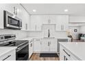 Modern kitchen featuring white cabinets, sleek countertops, and stainless steel appliances at 8240 Jacaranda Ave, Seminole, FL 33777