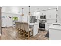 Bright, open kitchen with a central island, stainless steel appliances, and modern pendant lighting at 8240 Jacaranda Ave, Seminole, FL 33777