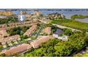 Gorgeous aerial view of the waterfront community featuring mature landscaping, a pond, and community pool at 11246 Kapok Grand Cir, Madeira Beach, FL 33708