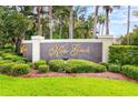 Elegant Kapok Grand community sign surrounded by manicured landscaping and mature trees at 11246 Kapok Grand Cir, Madeira Beach, FL 33708