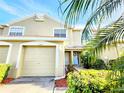 Well-maintained townhome featuring an attached garage, manicured landscaping, and a welcoming front entrance at 11246 Kapok Grand Cir, Madeira Beach, FL 33708