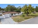 Charming one-story home featuring a manicured lawn, long driveway and established shade trees at 11350 112Th Ave, Largo, FL 33778