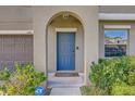 Home's entry with arched entryway, well-manicured bushes and ADT security for peace of mind at 11476 Sage Canyon Dr, Riverview, FL 33578
