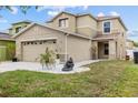Two-story home with a two car garage, lush green lawn and lovely rock garden at 12107 Fox Bloom Ave, Gibsonton, FL 33534