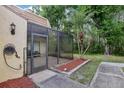 View of a screened porch with tile flooring and an outdoor hose-holder next to a narrow walkway at 12736 Wood Trail Blvd, Tampa, FL 33625