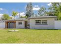 Beautifully landscaped single-story home with brick and plank siding and a well-maintained lawn at 1717 Thames St, Clearwater, FL 33755