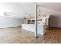 Open-concept living space featuring wood-look floors, modern lighting, and seamless flow to the kitchen at 1760 Sharondale Dr, Clearwater, FL 33755