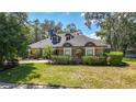 Well-manicured lawn with verdant landscaping frames this attractive single-story brick home with dormer windows at 213 Sheffield E Cir, Palm Harbor, FL 34683