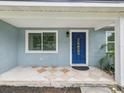 Inviting entryway featuring a blue front door, tile flooring, and a classic window at 232 Emerald Ln, Largo, FL 33771