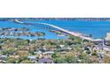 Scenic aerial view showcases waterfront homes, lush trees, and a beautiful bridge spanning the expansive blue waters at 2525 W Bay Dr # A20, Belleair Bluffs, FL 33770