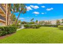 Expansive green lawn with tropical landscaping, perfect for outdoor activities at 2525 W Bay Dr # A20, Belleair Bluffs, FL 33770