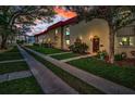 Exterior view of multiple townhomes featuring sidewalks and lush landscaping at sunset at 2700 Bayshore Blvd # 547, Dunedin, FL 34698