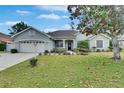 Charming single-story home with a well-manicured lawn and mature trees, showcasing its inviting curb appeal at 3004 Spring Hammock Dr, Plant City, FL 33566