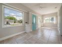 Bright sunroom with tile flooring, large windows, and a charming blue front door at 302 W Hilda St, Tampa, FL 33603
