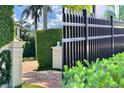 Close-up showcasing the manicured landscaping, including privacy hedges and decorative fencing at 3087 Cherry Ln, Clearwater, FL 33759