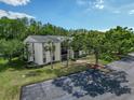 Apartment building with mature trees and well-maintained landscaping, complemented by ample parking at 3188 Lake Pine S Way # B1, Tarpon Springs, FL 34688