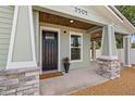 Inviting front porch with stone accents, a 'Welcome' mat, and stylish light fixtures at 3505 N Dartmouth Ave, Tampa, FL 33603