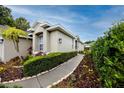 Inviting front elevation featuring manicured hedges and a paved walkway at 3726 Rain Tree Ct, Palm Harbor, FL 34685