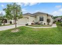 Single story home featuring a lush green lawn and cozy patio seating at 5116 Gato Del Sol Cir, Wesley Chapel, FL 33544